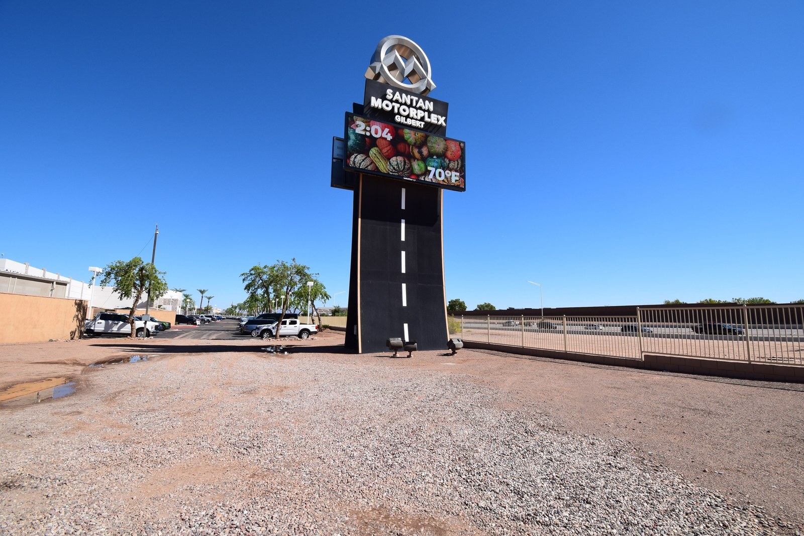 Wide view of the San Tan Motorplex tower sign with its new LED display and the lot in front of it